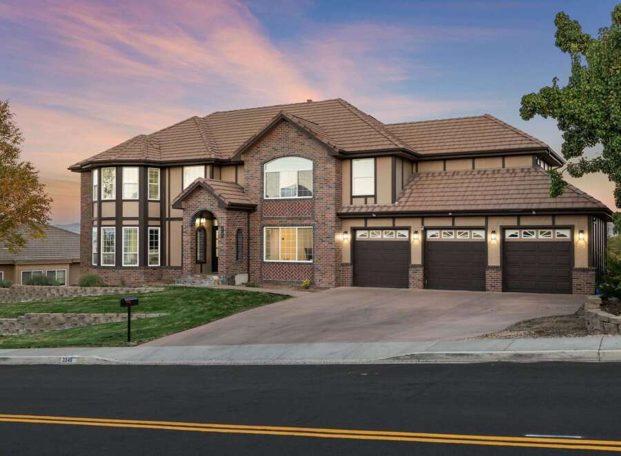This stunning two-story home boasts a striking brick and stucco exterior, complemented by a durable tile roof.