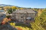 This stunning multi-story home boasts a spacious backyard perfect for entertaining, featuring multiple decks and a built-in grill area.