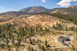 Experience luxury living in this stunning mountain home, nestled amidst a landscape of pine trees and rolling hills.