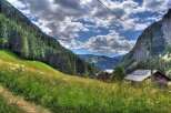 Secluded mountain chalet with solar panels, nestled in a lush alpine meadow.