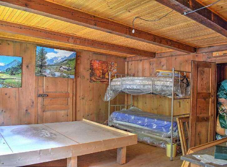 Rustic wooden cabin with bunk beds and scenic wall art.