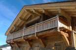 This stunning chalet boasts a beautiful wooden exterior with a large balcony, perfect for enjoying the mountain views.