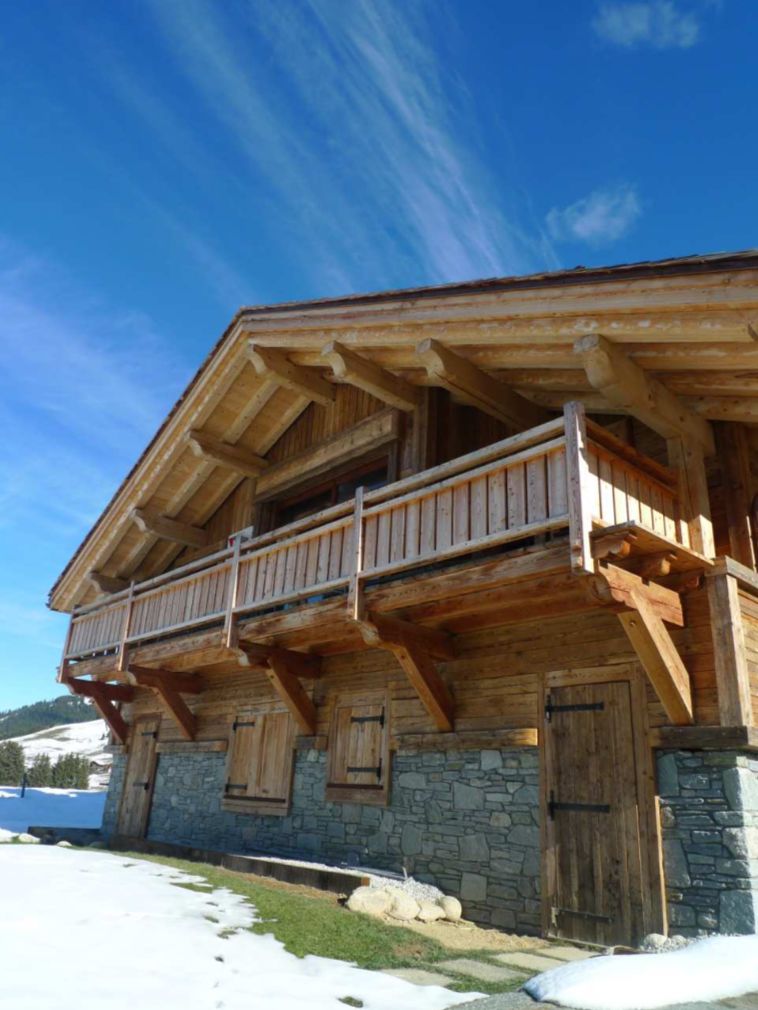 This stunning chalet boasts a beautiful wooden exterior with a large balcony, perfect for enjoying the mountain views.