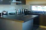 This stunning kitchen boasts a modern design with sleek gray cabinetry and a spacious island.