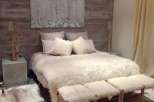 Cozy up in this luxurious bedroom featuring a plush sheepskin throw and handcrafted wooden stools.