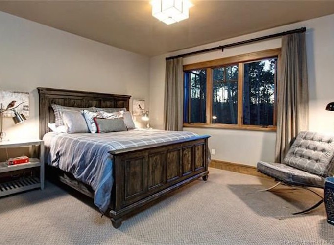 This stunning bedroom boasts a king-size bed, plush carpeting, and large windows offering breathtaking views.