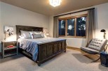 This stunning bedroom boasts a king-size bed, plush carpeting, and large windows offering breathtaking views.