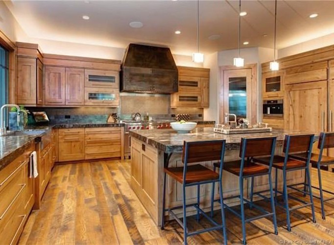 This stunning kitchen boasts a rustic-chic design with custom wood cabinetry, granite countertops, and high-end appliances.