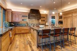 This stunning kitchen boasts a rustic-chic design with custom wood cabinetry, granite countertops, and high-end appliances.