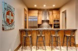 This stunning kitchen boasts a rustic-chic design with wood cabinetry, stainless steel appliances, and a granite countertop breakfast bar.