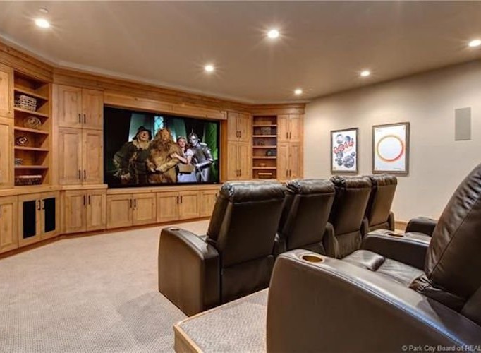 This luxurious home theater boasts a large projection screen, comfortable reclining seats, and custom built-in cabinetry.