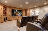 This luxurious home theater boasts a large projection screen, comfortable reclining seats, and custom built-in cabinetry.