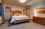This stunning bedroom boasts a king-size bed, plush bedding, and a gorgeous wooden headboard.