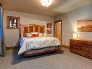 This stunning bedroom boasts a king-size bed, plush bedding, and a gorgeous wooden headboard.