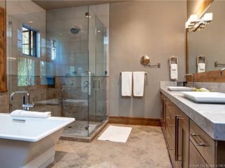 Luxurious bathroom boasts a spacious glass shower, soaking tub, and double vanity with ample counter space.