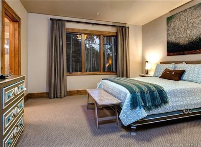 This stunning bedroom boasts a cozy and elegant atmosphere, featuring large windows that offer breathtaking views and allow ample natural light to flood the space.