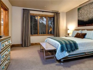 This stunning bedroom boasts a cozy and elegant atmosphere, featuring large windows that offer breathtaking views and allow ample natural light to flood the space.