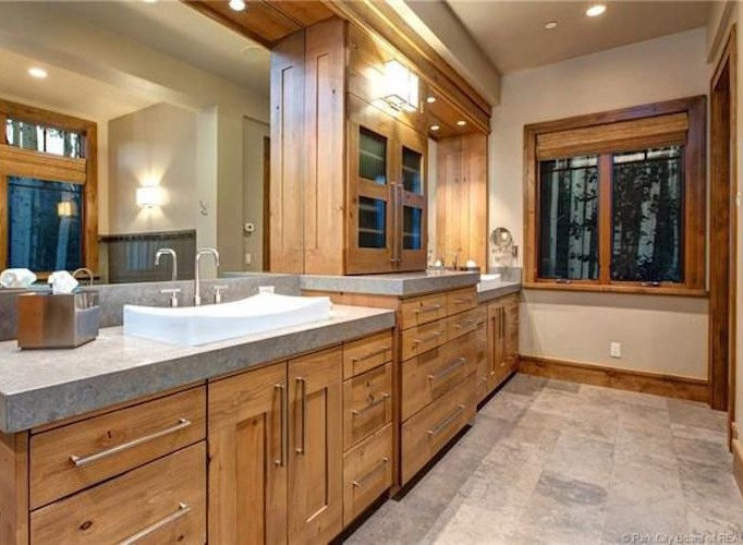 This luxurious bathroom boasts a stunning double vanity with ample storage, complemented by a large mirror reflecting the elegant wood finishes.