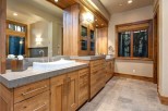 This luxurious bathroom boasts a stunning double vanity with ample storage, complemented by a large mirror reflecting the elegant wood finishes.