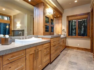 This luxurious bathroom boasts a stunning double vanity with ample storage, complemented by a large mirror reflecting the elegant wood finishes.