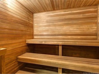 Relax and rejuvenate in this luxurious sauna, featuring rich wood paneling and spacious seating.