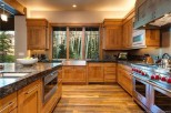 This stunning kitchen boasts a rustic-chic design with custom wood cabinetry, granite countertops, and high-end stainless steel appliances.