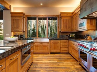 This stunning kitchen boasts a rustic-chic design with custom wood cabinetry, granite countertops, and high-end stainless steel appliances.