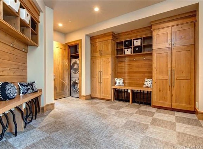 This stunning property boasts a spacious laundry room with built-in cabinetry and a convenient bench for added storage and functionality.