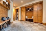 This stunning property boasts a spacious laundry room with built-in cabinetry and a convenient bench for added storage and functionality.