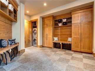 This stunning property boasts a spacious laundry room with built-in cabinetry and a convenient bench for added storage and functionality.