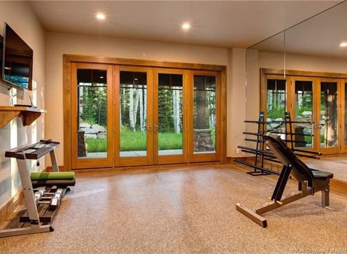 This stunning home boasts a private gym, complete with state-of-the-art equipment and large windows offering scenic views.
