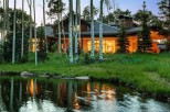 Luxury mountain home nestled amongst aspen trees, offering stunning views and a serene pond.