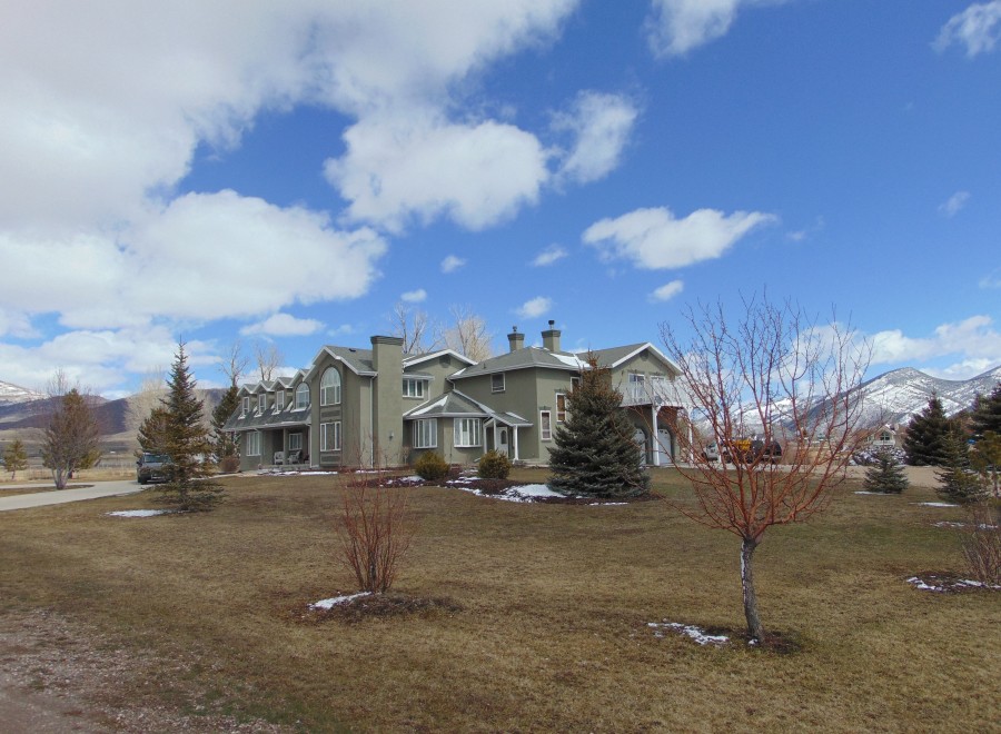 This stunning property boasts a large, custom-built home with expansive windows offering breathtaking mountain views.