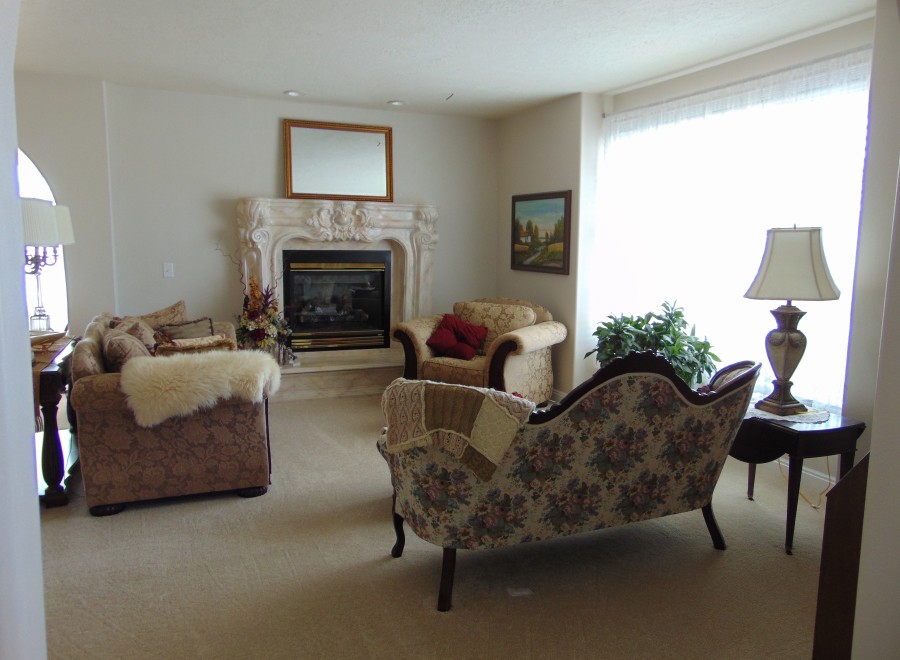 Cozy living room featuring a fireplace, plush seating, and large windows.