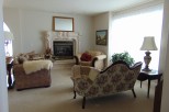 Cozy living room featuring a fireplace, plush seating, and large windows.