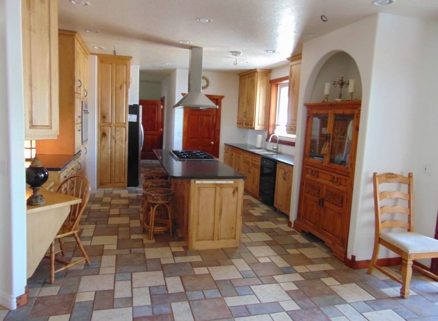 This stunning kitchen boasts a spacious layout with custom wood cabinetry, a large island with seating, and high-end appliances.