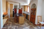 This stunning kitchen boasts a spacious layout with custom wood cabinetry, a large island with seating, and high-end appliances.