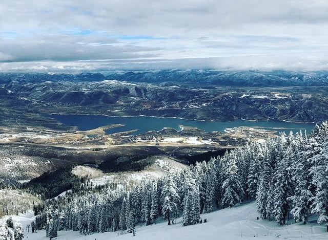 Breathtaking panoramic views of a pristine lake nestled in a snow-covered mountain range.