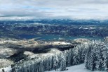 Breathtaking panoramic views of a pristine lake nestled in a snow-covered mountain range.