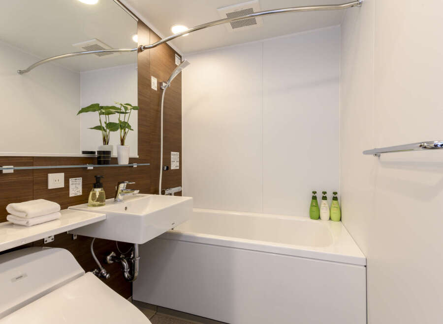 This modern bathroom boasts a sleek design with a built-in bathtub and shower, perfect for relaxation after a long day.