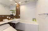 This modern bathroom boasts a sleek design with a built-in bathtub and shower, perfect for relaxation after a long day.