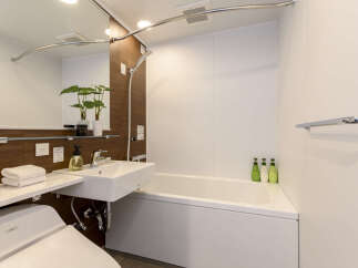 This modern bathroom boasts a sleek design with a built-in bathtub and shower, perfect for relaxation after a long day.