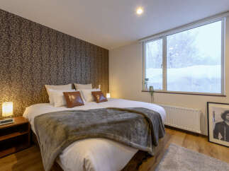 Cozy bedroom with a king-size bed, plush bedding, and a large window offering stunning views.