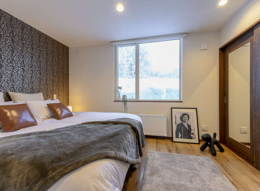 Cozy bedroom with a king-size bed, plush bedding, and a large window offering scenic views.