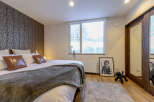 Cozy bedroom with a king-size bed, plush bedding, and a large window offering scenic views.