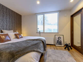 Cozy bedroom with a king-size bed, plush bedding, and a large window offering scenic views.