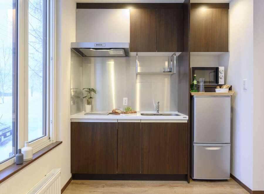 Cozy studio apartment featuring a well-equipped kitchenette with modern appliances.