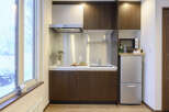 Cozy studio apartment featuring a well-equipped kitchenette with modern appliances.