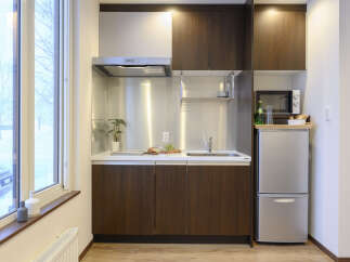 Cozy studio apartment featuring a well-equipped kitchenette with modern appliances.