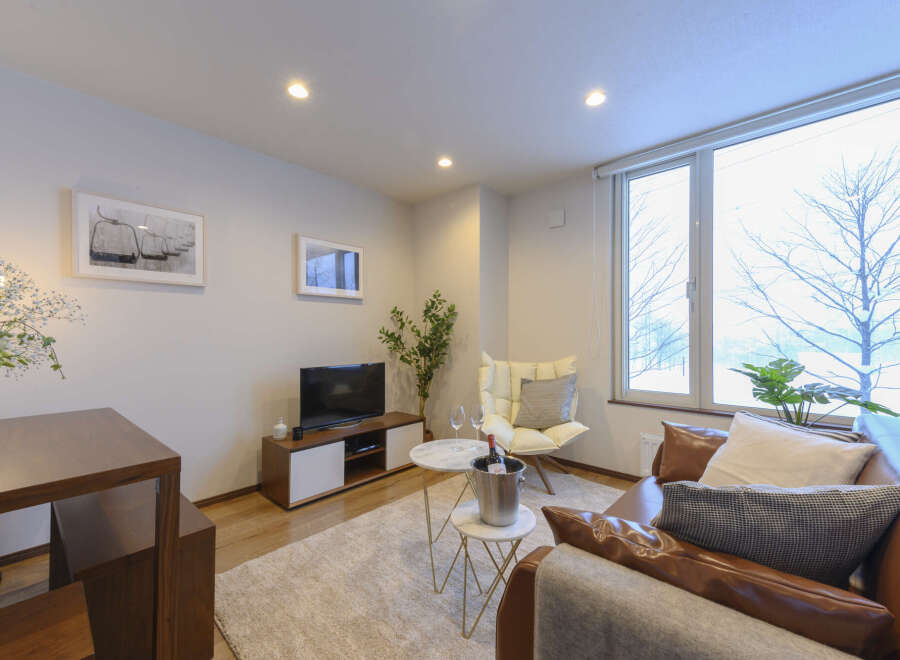 Cozy living room with large window overlooking snowy landscape.